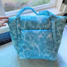 New With Tag. First Two Pictures Taken By Me. Color: Pool A Mini Cloud Bag That Actually Feels Like A Cloud. Soft, Puffy Exterior Keeps Your Essentials Cozy. Exterior Pocket. Machine Washable. 100% Recycled Ripstop Nylon, Recycled Pet Polyfill 10"H 15.75"W (At Opening, 10" At Base) 5.5"D 11" Strap Drop ** First Time On Poshmark? Use Code Emmmamercer When You Create Your Poshmark Account To Receive A $10 Credit Toward Your First Purchase. ** Blue Tote Bag For Weekend, Casual Blue Shoulder Bag For Weekend, Blue Rectangular Bag For Weekend, Blue Rectangular Weekend Bag, Blue Shoulder Bag For Summer Weekends, Blue Shoulder Bag For Weekend In Summer, Blue Shoulder Bag For Weekend, Trendy Blue Bag For Weekend, Blue Shoulder Bag For The Weekend