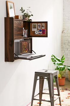 a laptop computer sitting on top of a wooden shelf next to a metal bar stool