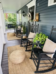 the front porch is decorated with rocking chairs and plants