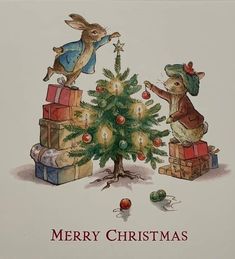 a christmas card with two rabbits decorating a tree