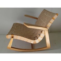 a wooden rocking chair made out of cardboard with woven seat padding and back support