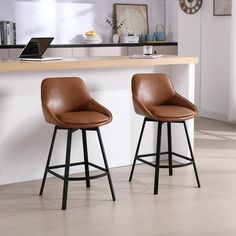 two brown leather bar stools sitting in front of a counter