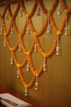 orange and white garlands hanging from the side of a wall with bells attached to it