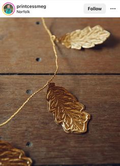 a gold leaf necklace on a wooden table