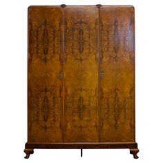 an antique wooden armoire with intricate carvings on the front and sides, against a white background