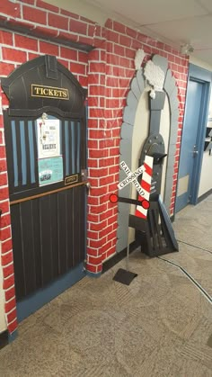 an entrance to a ticket booth with a red brick wall