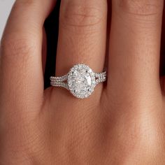 a woman's hand with a diamond ring on top of her finger and an engagement band