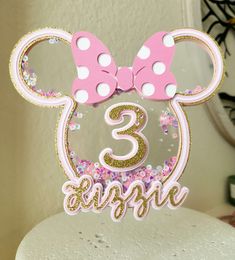 a minnie mouse cake topper with the number 3 on it