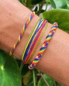 a close up of a person's arm wearing three different colored bracelets on top of each other