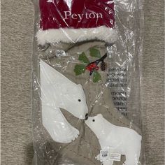 two white polar bears in a christmas stocking with holly leaves and berries on it