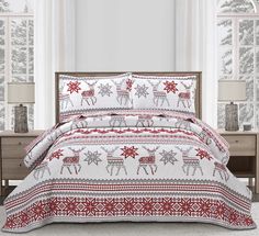 a bed with red and white christmas decorations on it in front of a large window