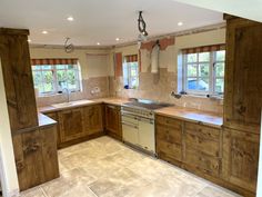 an empty kitchen with wooden cabinets and tile flooring, including a stove top oven