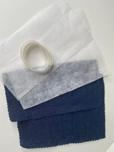 three different colors of fabric with one white ring on top and the other dark blue