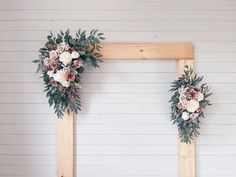 two wooden frames decorated with flowers and greenery