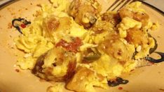 an omelet with meat and vegetables is on a brown plate next to a fork