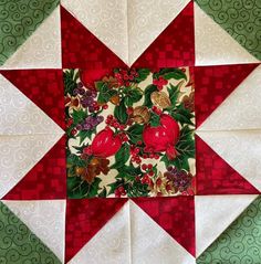 a red and white quilted star with pomegranates on it