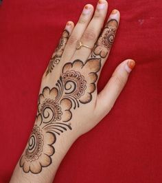 a woman's hand with henna tattoos on it