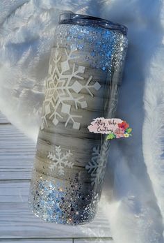 the tumbler is decorated with snowflakes and glitters