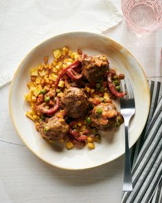 a white plate topped with meatballs and vegetables