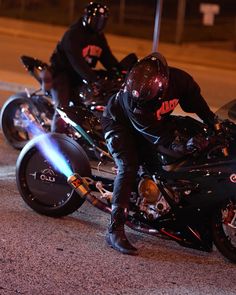 two motorcyclists are riding their bikes on the street at night time,