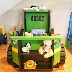 a green toy truck with stuffed animals on it's shelf and the name adler