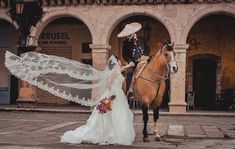 the bride and groom are riding their horse together in front of an old building with arches