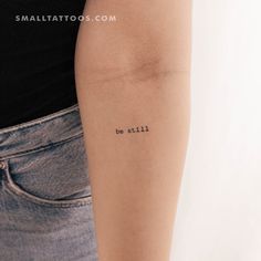 a woman's arm with the word be still tattooed on her left arm, in black ink