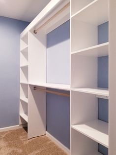 an empty closet with white shelves and blue walls