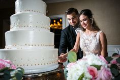 a newly married couple cutting their wedding cake