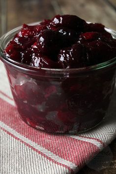 a glass bowl filled with cranberry sauce on top of a table