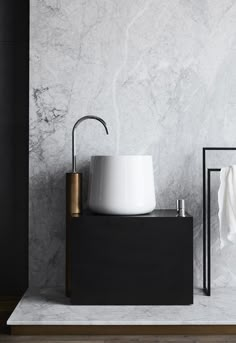 a white sink sitting on top of a counter next to a black and white wall