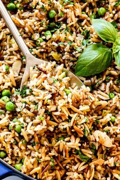 rice and peas are mixed together in a blue bowl with a spoon on the side