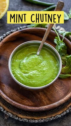 a wooden bowl filled with green liquid and garnished with cilantro