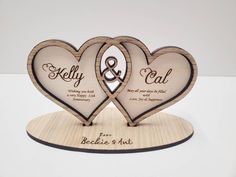 two heart shaped wooden plaques with names on them