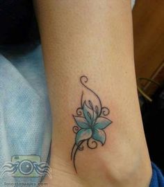 a woman's foot with a blue flower tattoo on the left side of her ankle