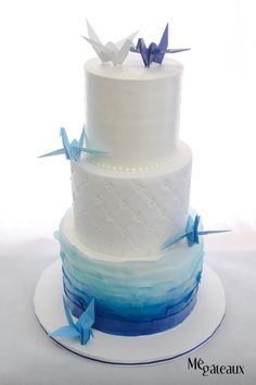 a three tiered cake with blue and white frosting