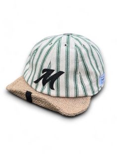 The Makshy custom striped baseball cap effortlessly blends classic style with individualistic flair. Its form-fitting design and comfortable fabric ensure a polished look, while the customisable letter motif and antique-style metal squatchee add a touch of vintage charm. This fashion-forward cap offers versatility with its adjustable and rollable visor, perfect for adapting to different styling preferences. Crafted for convenience, its foldable design makes it ideal for on-the-go wear and easy packing during travels. Metal eyelets enhance breathability, ensuring comfort in any weather. FEATURES * Off-white cotton herringbone green striped fabric with a beige jute visor * Foldable eight-panel unisex design * Adjustable and rollable visor with built-in wire * Customisable velcro letter emble Panel Hat, Custom Initials, Green Stripes, Unisex Design, Antique Style, Herringbone, Vintage Charms, Baseball Cap, Classic Style