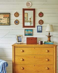 a dresser with many pictures on the wall