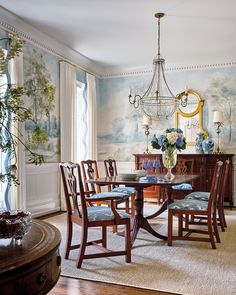 a formal dining room with blue and white wallpaper