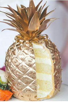 a pineapple shaped cake sitting on top of a white table next to strawberries