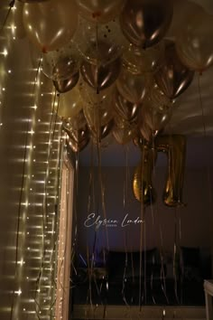 balloons and streamers are hanging from the ceiling in front of a doorway with lights