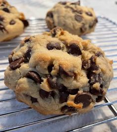 three chocolate chip cookies cooling on a rack