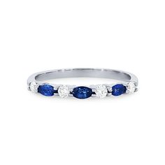 a white gold ring with three blue sapphire stones on the side and two diamonds in the middle