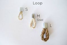 three pieces of rope hanging from hooks on a white wall with the words loop and m sisal