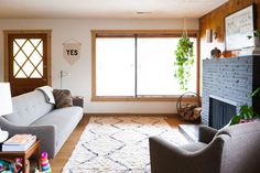 a living room filled with furniture and a fire place in front of a large window