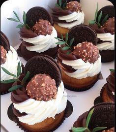 chocolate cupcakes with white frosting and sprinkles are arranged in a box