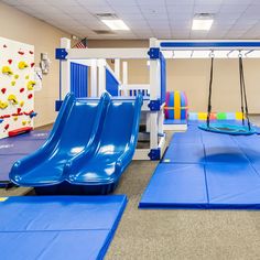 an indoor play area with slides and swings