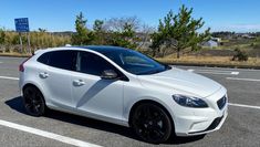 a white car is parked on the side of the road