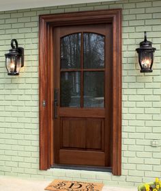 a wooden front door with two lights on the side