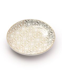 a white and black plate on a white surface with an intricate design in the center